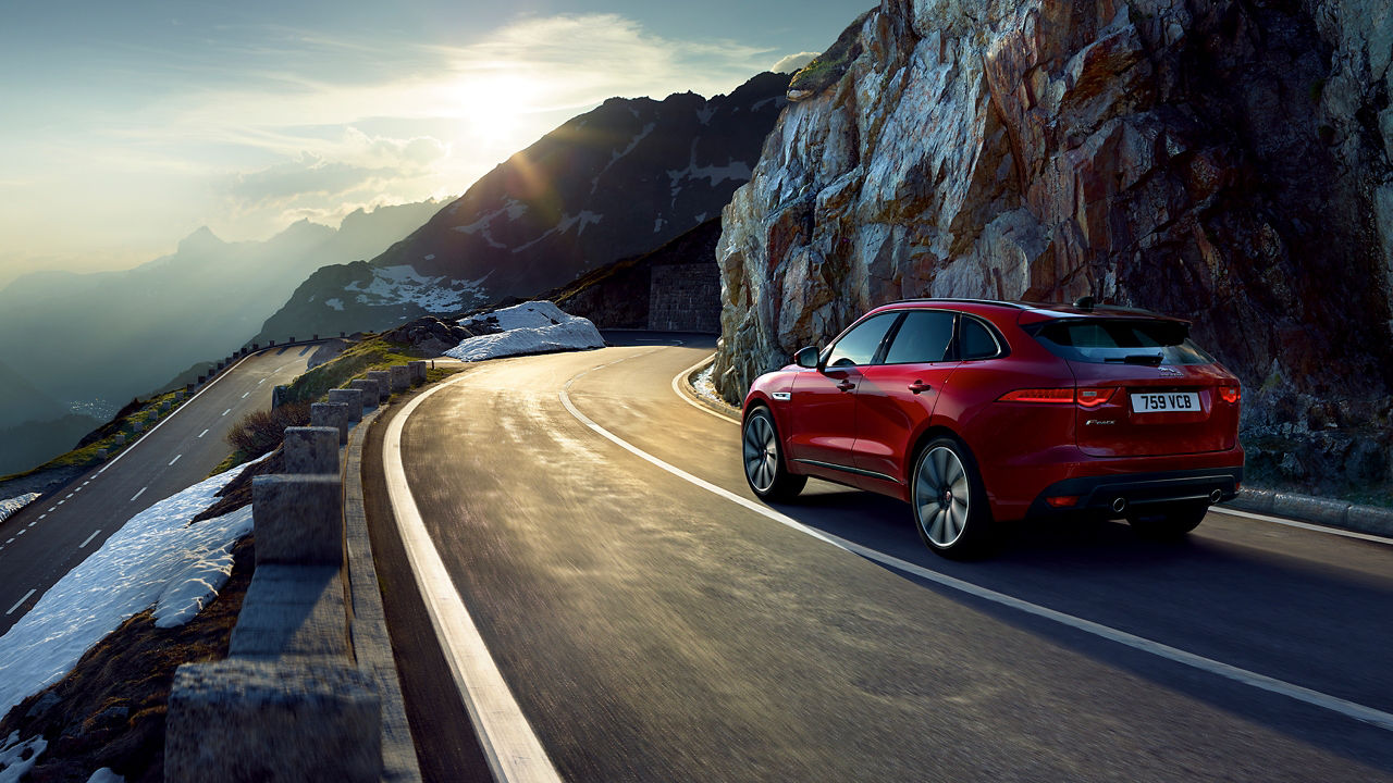 Jaguar F-PACE running on hill road